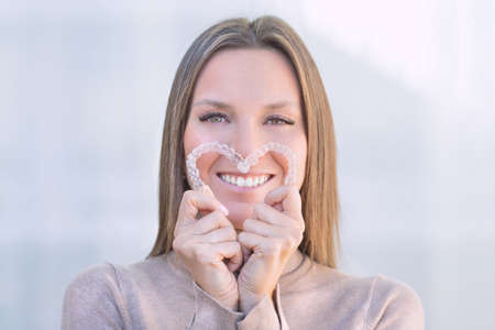 Woman with perfect smile after invisible dental aligners aligners treatment