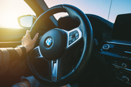 BMW G30 5-series M-package steering wheel. Woman is holding sport fast car steering wheel. 13.05.2023 Tallinn, Estoniaのeditorial素材
