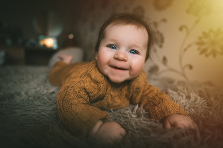 Adorable cute baby girl lying on bed and smiling. Adorable kid portrait. 5 month old child. Childhood concept.の写真素材