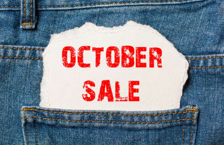 October sale on white paper in the pocket of blue denim jeansの写真素材