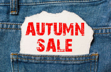 autumn sale on white paper in the pocket of blue denim jeansの写真素材
