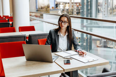 Girl works on a laptop in the workplace. Successful business woman creates a startup and makes decisions.の写真素材