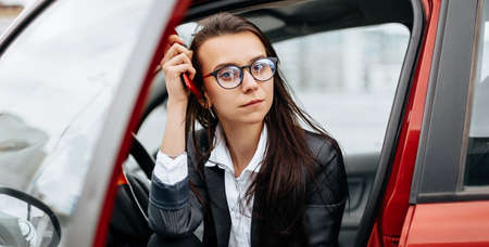 The girl in the car. A woman in a parking lot sits in a auto.の写真素材