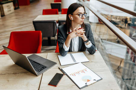 Girl works on a laptop in the workplace. Successful business woman creates a startup and makes decisions.の写真素材