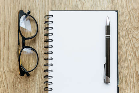 Pen and Notepad on the wooden desk. Business concept, blank sheet with place for advertising and lettering. Education and training supplies.の写真素材