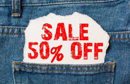 Sale 50 off on white paper in the pocket of blue denim jeansの写真素材