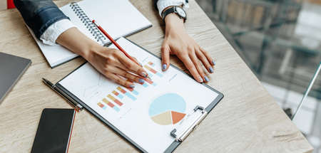 Business woman checks charts and refreshes financial progress. The girl analyzes the business model...