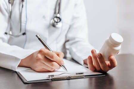 Doctor Writing Medical Pill Prescription for Patientの写真素材
