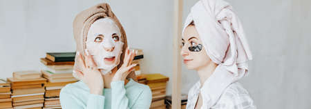 Two girls make masks and patches for the beauty of face and hair. Women take care of youthful skin....