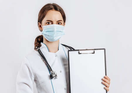 Doctor in mask with stethoscope and documents on white isolated backgroundの写真素材