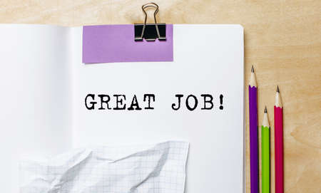 GREAT JOB text written on a paper with pencils on the desk in the officeの写真素材