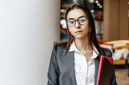 Businesswoman with documents for work. Student girl with folders with documentation. An officer will collect information.の写真素材