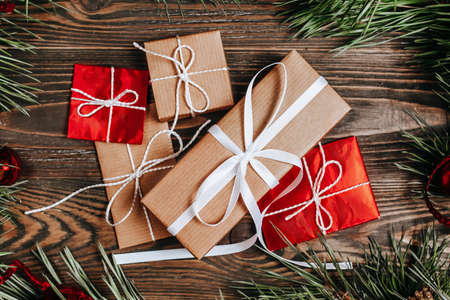 New year gifts on wooden background with christmas tree and toysの写真素材