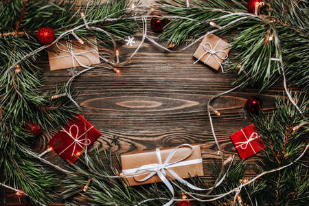 New year gifts on wooden background with christmas tree and toysの写真素材