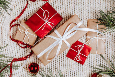 New year gifts on knitted background with christmas tree and toysの写真素材