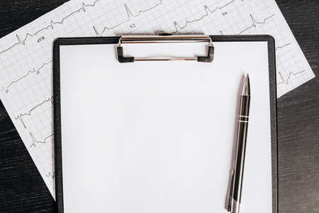 Blank background with pen and cardiogram on medical table