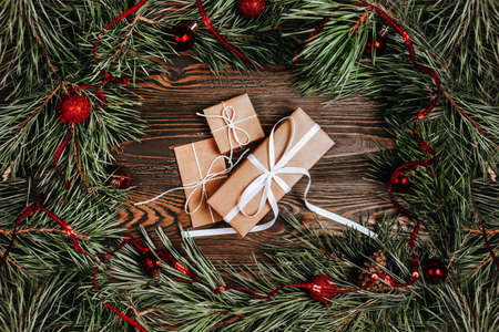 New year gifts on wooden background with christmas tree and toysの写真素材