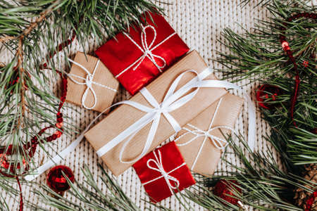 New year gifts on knitted background with christmas tree and toysの写真素材