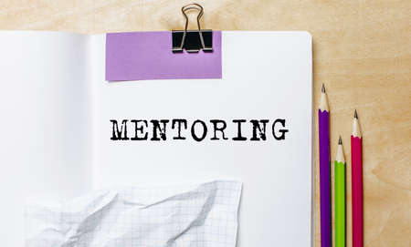 MENTORING text written on a paper with pencils on the desk in the officeの写真素材