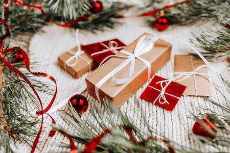 New year gifts on knitted background with christmas tree and toysの写真素材