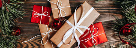 New year gifts on wooden background with christmas tree and toysの写真素材