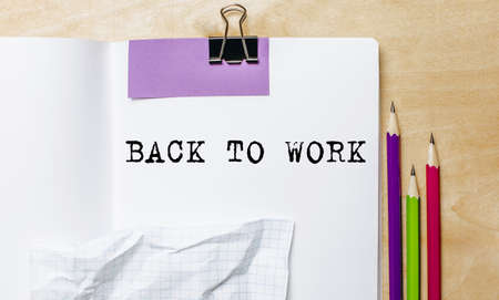 BACK TO WORK text written on a paper with pencils on the desk in the officeの写真素材