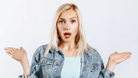 Beautiful young girl is surprised on gray isolated background