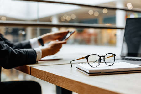 Glasses at the workplace in the office near the laptop and notepad. Business hours