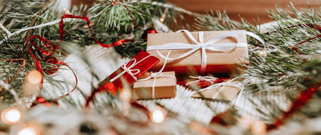 New year gifts on knitted background with christmas tree and toys in the lightsの写真素材