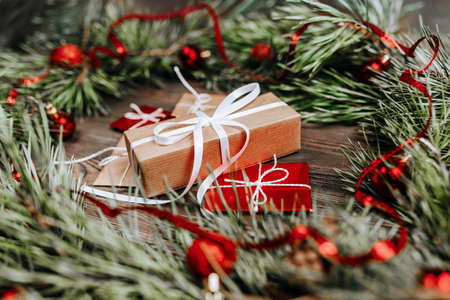 New year gifts on wooden background with christmas tree and toysの写真素材