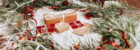 New year gifts on knitted background with christmas tree and toys in the lightsの写真素材