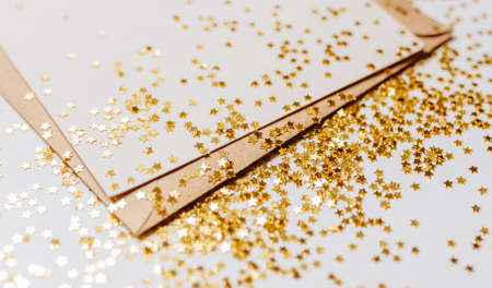 Blank note with envelope and gold glitter stars on white backgroundの写真素材