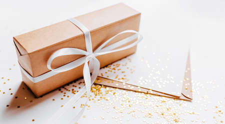 Gift and blank note with envelope, gold glitter stars on white backgroundの写真素材