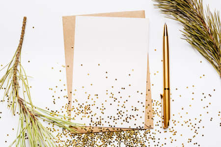 Blank note with envelope, spruce branch and gold pen on white background