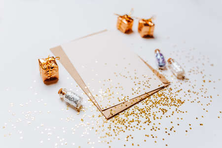Blank note with envelope, gifts and gold glitter stars on white background
