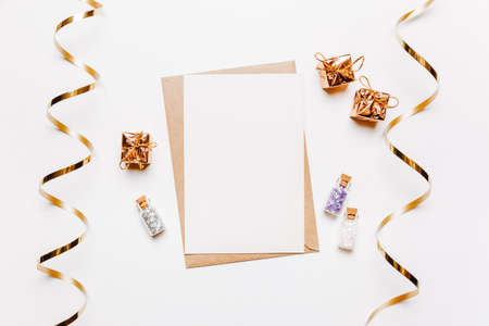Blank note with envelope, gifts and gold glitter stars on white backgroundの写真素材