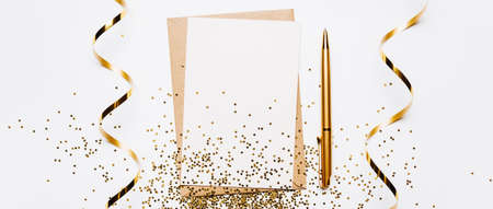 Blank note with envelope, ribbon, confetti, pen and gold glitter stars on white backgroundの写真素材