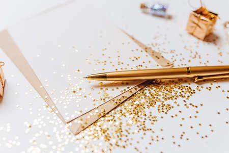 Blank note with envelope, pen and gold glitter stars on white backgroundの写真素材