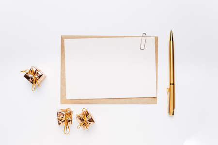 Blank note with envelope, pen and gold gifts on white backgroundの写真素材