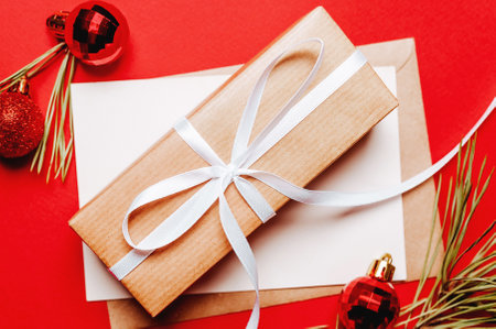 Christmas gift with fir branch and toy on red isolated background. New Year conceptの写真素材