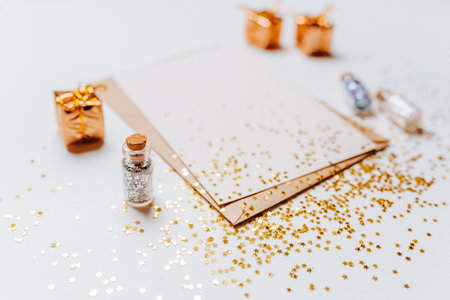 Blank note with envelope, gifts and gold glitter stars on white backgroundの写真素材