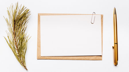 Blank note with envelope, spruce branch and gold pen on white backgroundの写真素材