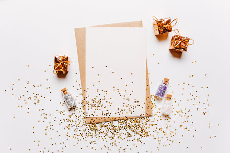 Blank note with envelope, gifts and gold glitter stars on white backgroundの写真素材
