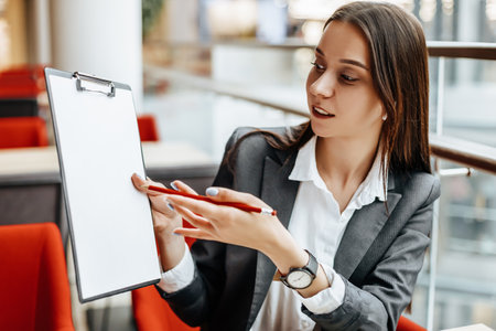 Girl works on a laptop in the workplace. Businesswoman shows and explains the goals and objectives for the business. Successful woman creates a startup and makes decisions.の写真素材