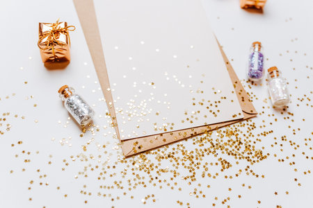 Blank note with envelope, gifts and gold glitter stars on white backgroundの写真素材