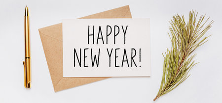 happy new year note with envelope, spruce branch and gold pen on white background. merry christmas and New Year conceptの写真素材