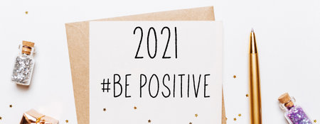 2021 be positive note with envelope, gifts and gold glitter stars on white background. merry christmas and New Year conceptの写真素材