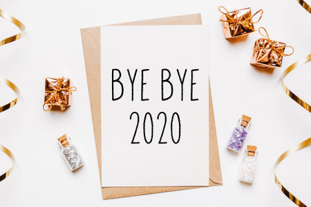 bye bye 2020 note with envelope, gifts and gold glitter stars on white background. merry christmas and New Year conceptの写真素材
