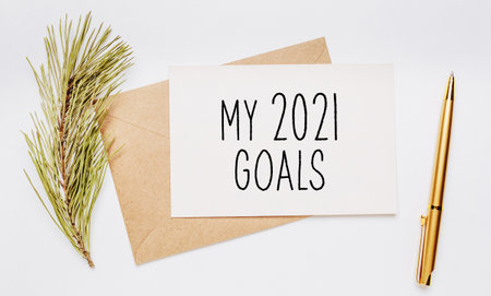 my 2021 goals note with envelope, spruce branch and gold pen on white background. merry christmas and New Year conceptの写真素材