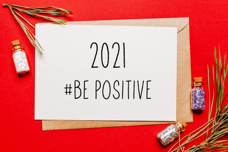 2021 be positive christmas note with gift, fir branch and toy on red isolated background. New Year conceptの写真素材